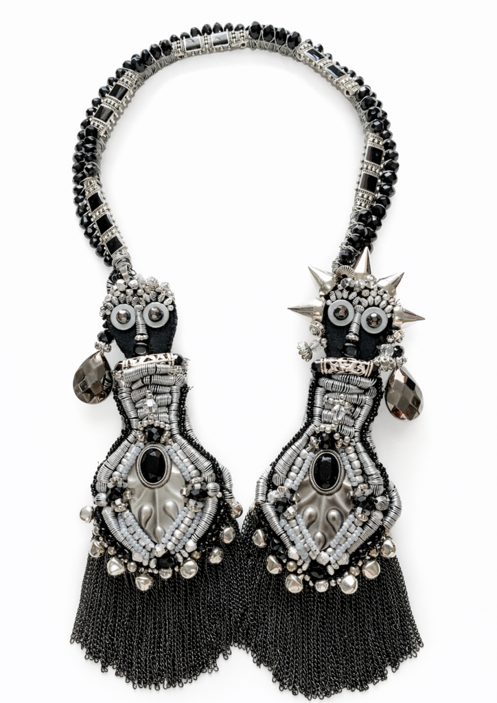 Pair of ornate black and silver earrings on a white background