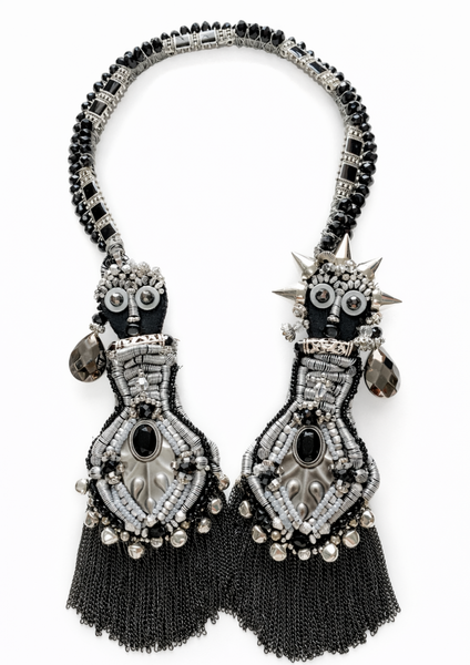 Pair of ornate black and silver earrings on a white background